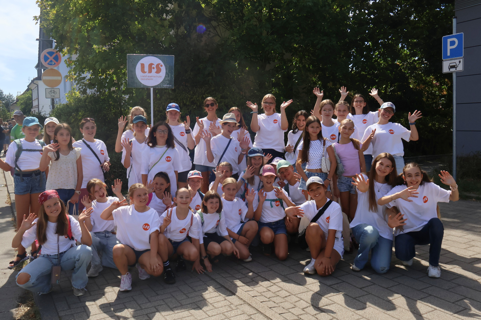Schülerinnen und Begleitpersonen der Liebfrauenschule stehen bei sonnigem Wetter gemeinsam für ein Gruppenfoto vor dem Winzerfestumzug. Schülerinnen und Begleitpersonen der Liebfrauenschule stehen bei sonnigem Wetter gemeinsam für ein Gruppenfoto vor dem Winzerfestumzug.