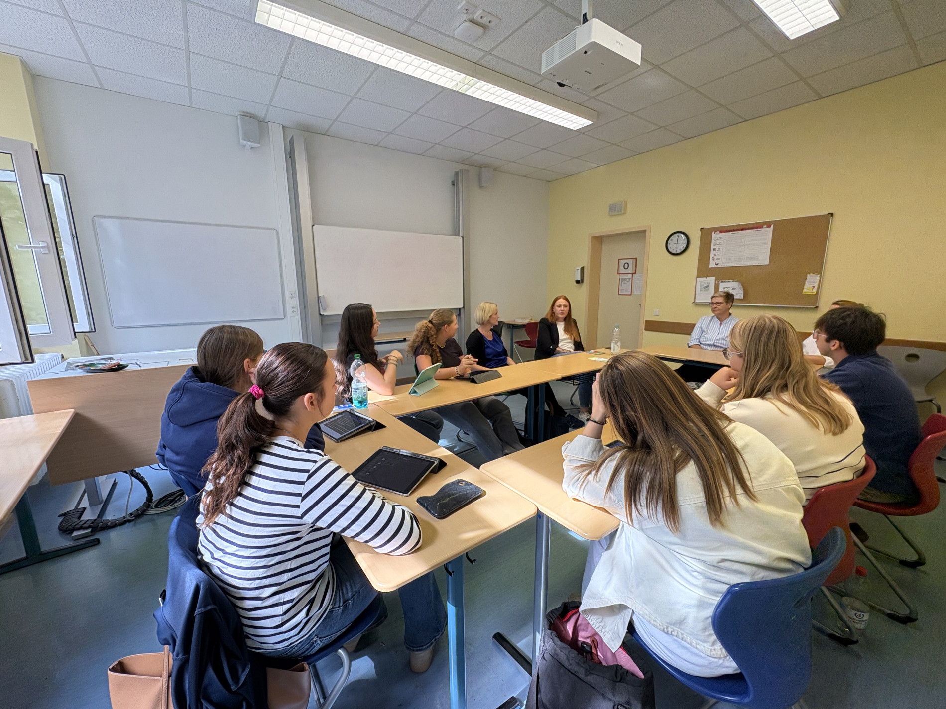 Eine Schülerin meldet sich, während die Jugendamtsmitarbeiterin und die übrige Klasse im Klassenraum im Gespräch sind. Eine Schülerin meldet sich, während die Jugendamtsmitarbeiterin und die übrige Klasse im Klassenraum im Gespräch sind.