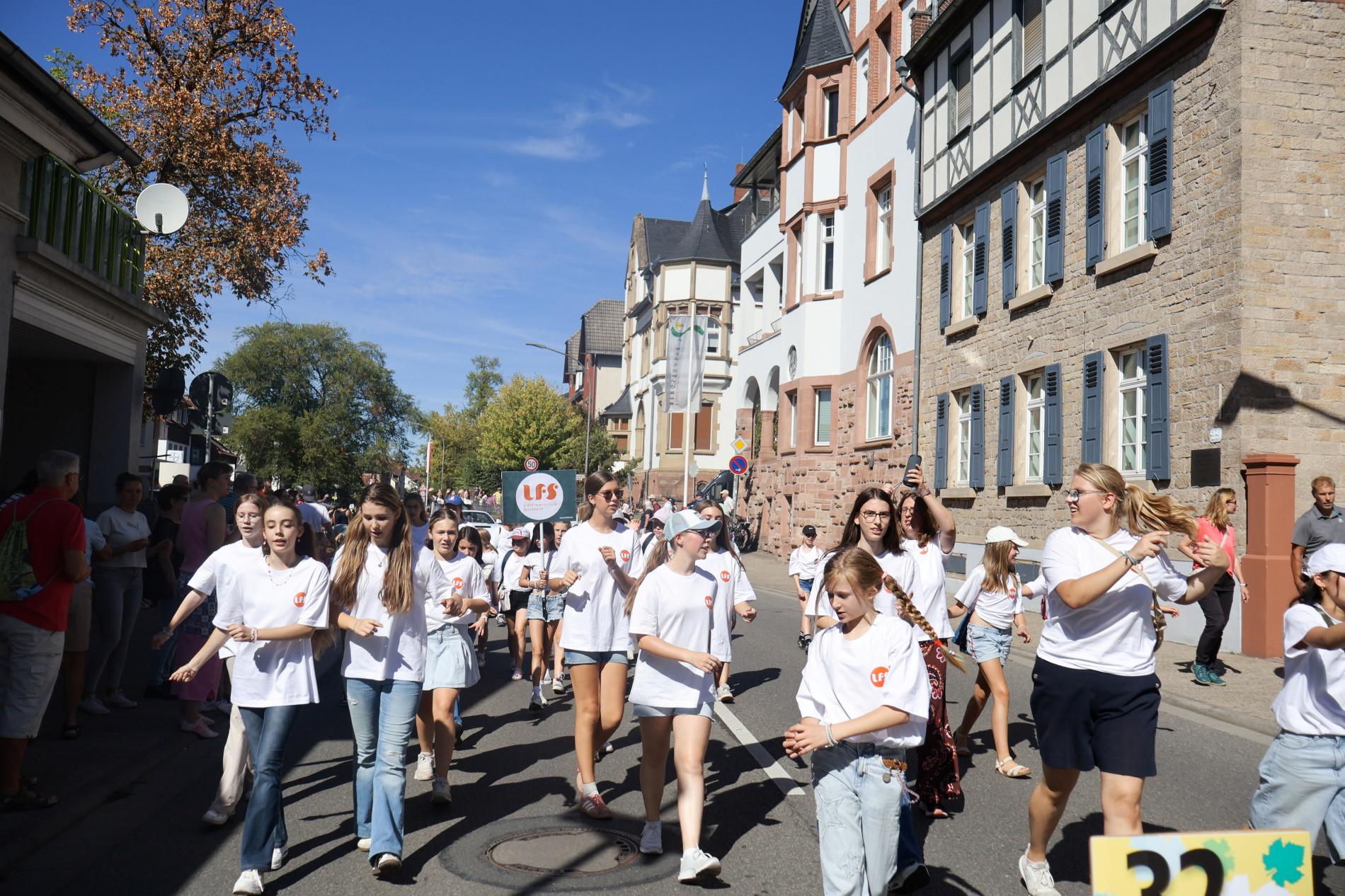 Eine größere Gruppe von LFS-Schülerinnen läuft bei sonnigem Wetter durch eine Straße in Bensheim während des Winzerfestumzugs. Eine größere Gruppe von LFS-Schülerinnen läuft bei sonnigem Wetter durch eine Straße in Bensheim während des Winzerfestumzugs.