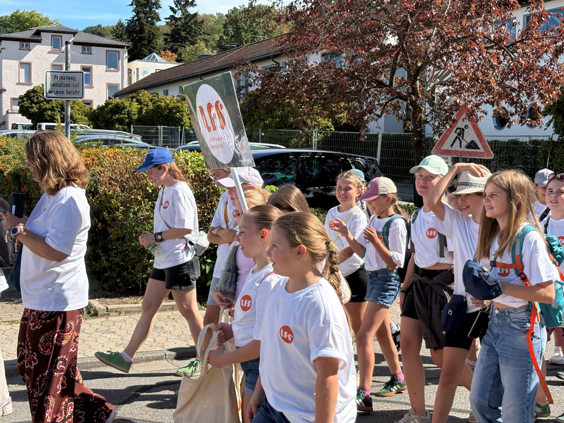 Schülerinnen der Liebfrauenschule laufen gemeinsam durch Bensheim und tragen ein Schild mit dem LFS-Logo. Schülerinnen der Liebfrauenschule laufen gemeinsam durch Bensheim und tragen ein Schild mit dem LFS-Logo.