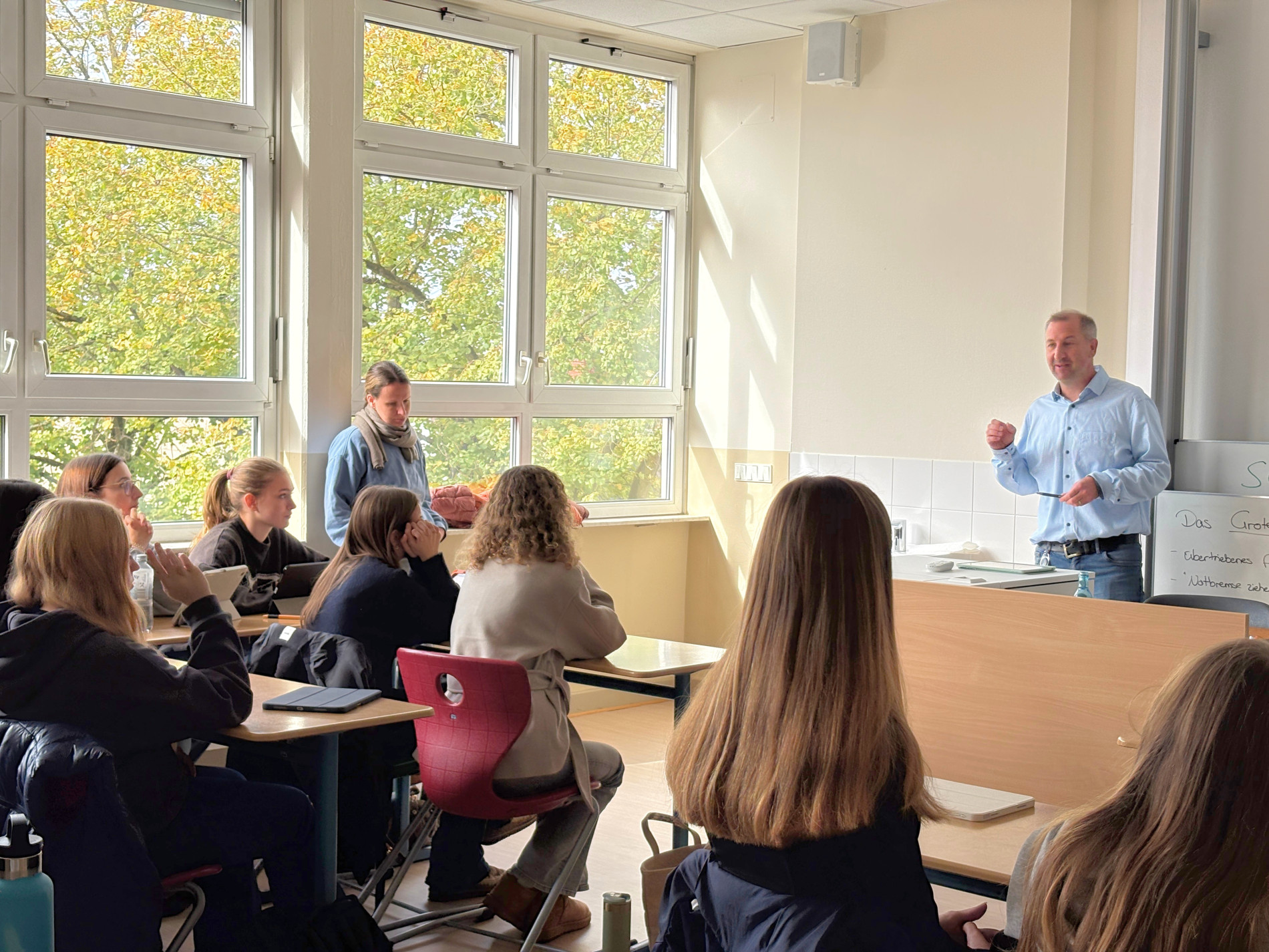 Ein Unternehmensvertreter von Sirona spricht vor einer Schulklasse über berufliche Möglichkeiten. Die Schülerinnen verfolgen seinen Vortrag. Ein Unternehmensvertreter von Sirona spricht vor einer Schulklasse über berufliche Möglichkeiten. Die Schülerinnen verfolgen seinen Vortrag.