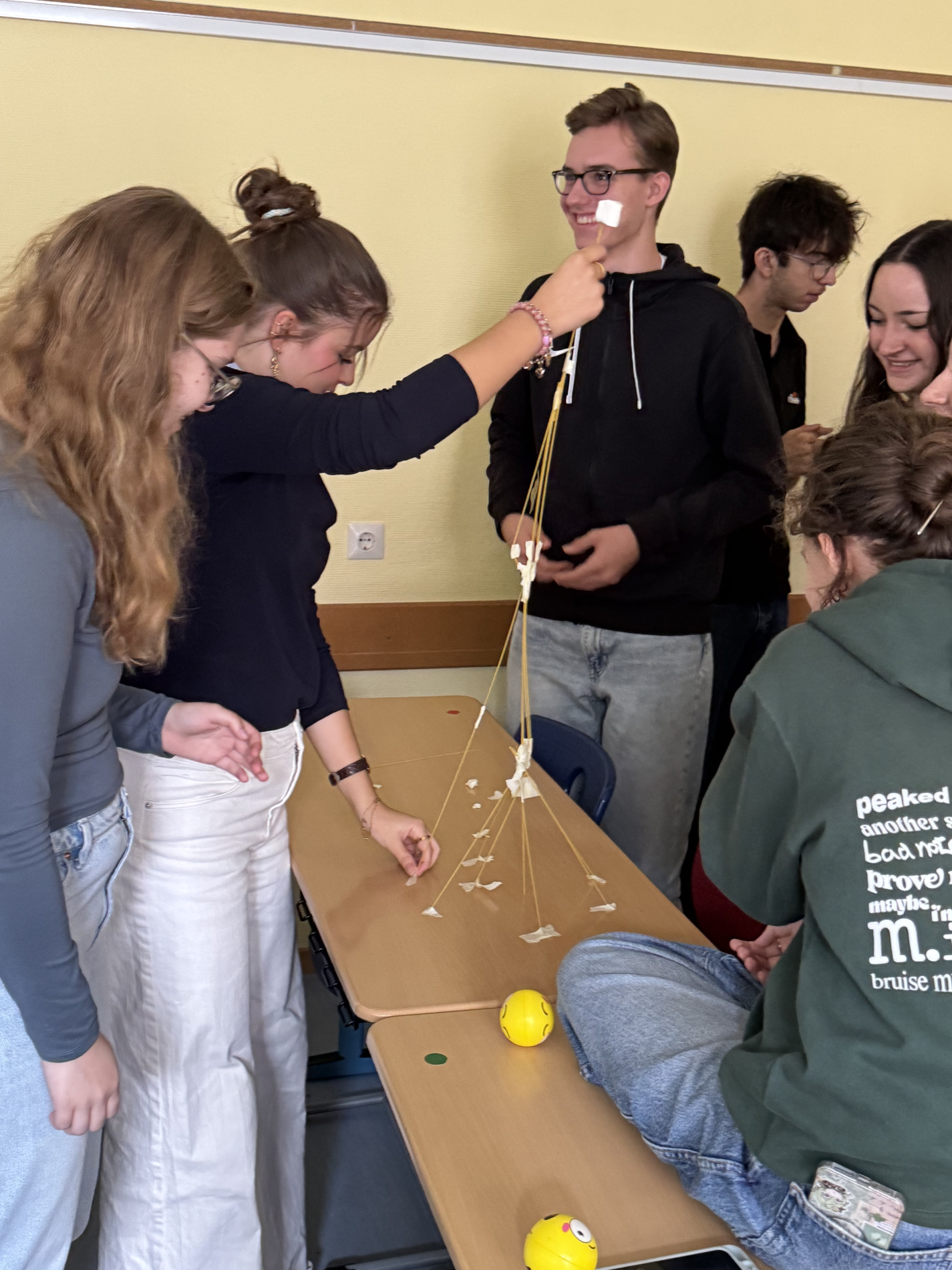 Mehrere Lernende arbeiten gemeinsam an einem Spaghetti-Turm und prüfen seine Stabilität. Mehrere Lernende arbeiten gemeinsam an einem Spaghetti-Turm und prüfen seine Stabilität.