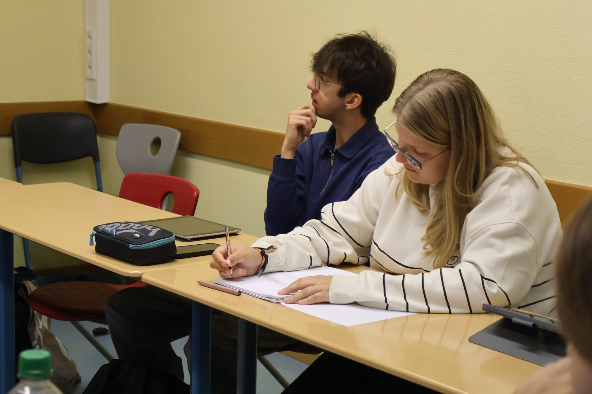 Eine Schülerin macht sich während des Gesprächs Notizen; daneben hört ein Mitschüler zu. Eine Schülerin macht sich während des Gesprächs Notizen; daneben hört ein Mitschüler zu.